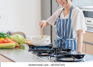 attractive asian woman cooking at kitchen