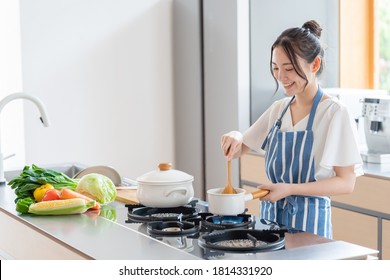 Attractive Asian Woman Cooking At Kitchen