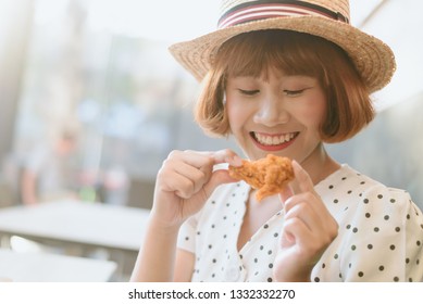 Attractive Asian Woman Eating Fried Chicken.