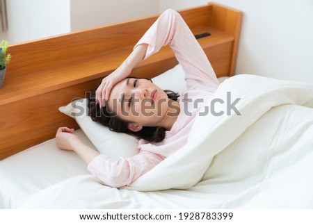 attractive asian woman in night clothes,bed,fatigue