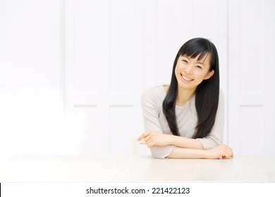 Attractive Asian Woman Relaxing In The All White Room