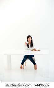 Attractive Asian Woman Relaxing In The All White Room