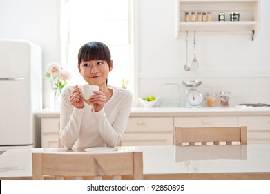 Attractive Asian Woman Relaxing In The Kitchen