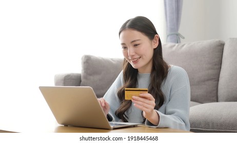 Attractive Asian Woman Shopping Online With A Credit Card