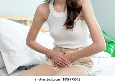 Attractive Asian Woman Sitting On Bed Have A Bladder Pain.