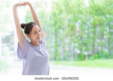 attractive asian woman stretching at living room - Powered by Shutterstock