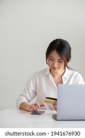 Attractive Asian Woman Using Her Credit Card For Online Shopping At Home