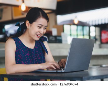 Attractive Asian woman using laptop in coffee shop. - Shutterstock ID 1276904074