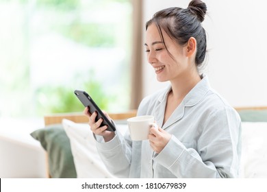 Attractive Asian Woman Using Smart Phone At Morning