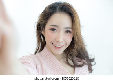Attractive Asian Woman using smartphone for selfie with happy emotion, People lifestyle concept. - Shutterstock ID 1058823620