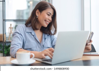 Attractive Asian Woman Working With Laptop In Her Office.