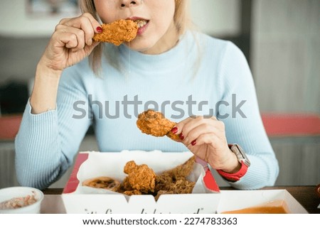 Attractive Asian women eating fried chicken
