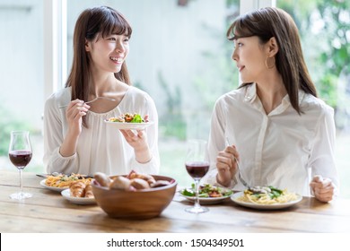 Attractive Asian Women Enjoying Lunch In Living Room