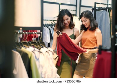 Attractive Asian Women Shopping For Clothes On Sale