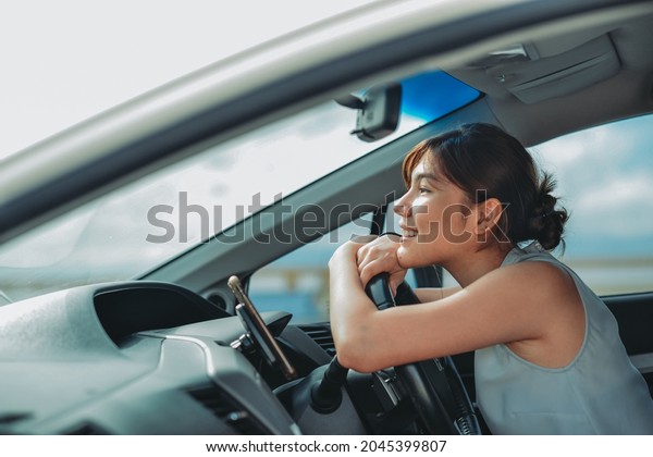 attractive\
asian women smiling and looking straight while driving a car.\
travel vacation Relaxing and enjoying\
concept.