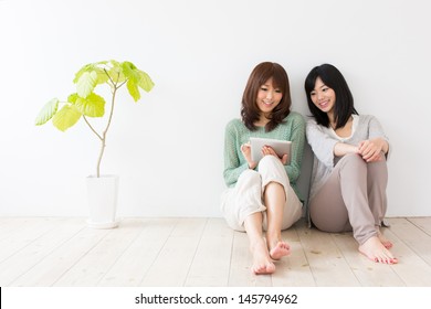 Attractive Asian Women Using Tablet Computer In The Room