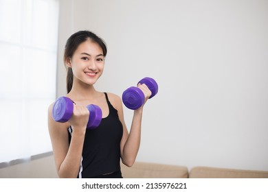 Attractive Asian Young Fitness Woman Lifting Dumbbell Weights Workout At Home In Living Room. Fresh Feeling Female Training And Exercise Wearing Sport Wear Fit Body.