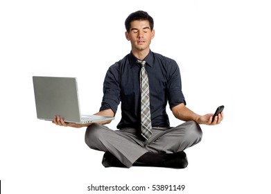 An attractive athletic businessman doing a yoga pose while using his mobile phone and laptop against white background