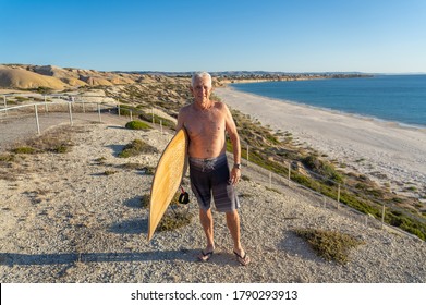 Attractive Australian Mature Man Surfer With Cool Vintage Surfboard On Beach At Sunset. Senior Adult Happy To Be Back To Surf . Outdoors Sports Adventure, Active Older People And Retirement Lifestyle.