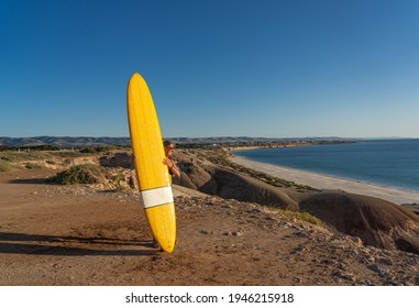 Attractive Australian Mature Surfer With Cool Vintage Surfboard At Sunset. Fit Woman In Her 50s Happy To Be Back To Surf . Outdoors Sports Adventure, Active Older People And Retirement Lifestyle.