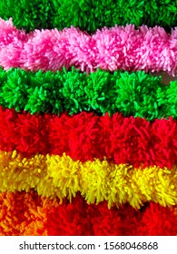 An attractive backround of multicolred string of pom poms aranged side by side - wool craft