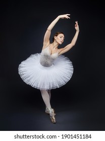 attractive ballerina poses gracefully in the studio on a black background