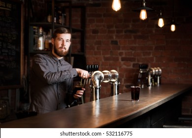 Attractive bartender is pouring a beer - Powered by Shutterstock