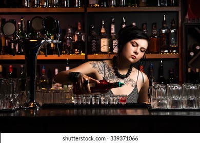 Attractive bartender pouring a drink