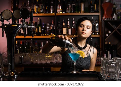 Attractive bartender pouring a drink