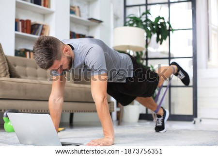 Attractive beared man doing plank exercise at home. Fitness is the key to health.