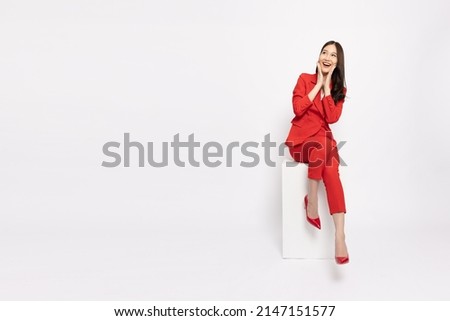 Attractive beautiful Asian business woman sitting on white box, Excited female concept