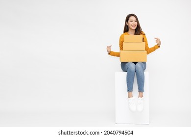 Attractive Beautiful Asian Woman Sitting On White Box With Parcel Box, Delivery And Shipping Concept