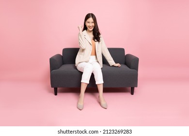 Attractive Beautiful Asian Woman Sitting On Sofa And Hands Up Raised Arms From Happiness, Excited Businesswoman Winner Success Concept