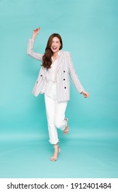 Attractive beautiful Asian woman standing and hands up raised arms from happiness isolated on green background, Excited businesswoman winner success concept