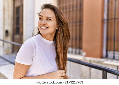 Attractive and beautiful hispanic woman smiling happy on a sunny day outdoors. Pretty brunette girl with positive smile looking confident at the city - Powered by Shutterstock