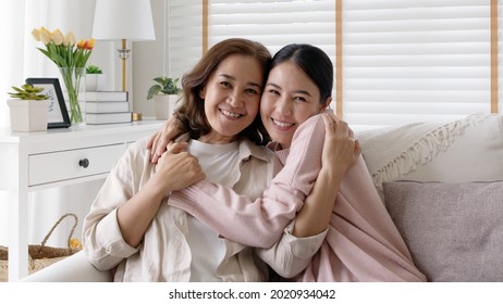 Attractive beautiful mum sit at cozy sofa couch living room in family moment grown up child kid look camera celebrate joy good warm time relationship with retired overjoy lady girl life insurance.