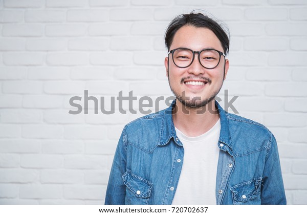 魅力的な美しいポジティブなアジア人男性 接写のアジアのオタク男性 白い背景に大きな笑みを浮かべた眼鏡をかけたハンサムなオタクの日本人男性 の写真素材 今すぐ編集