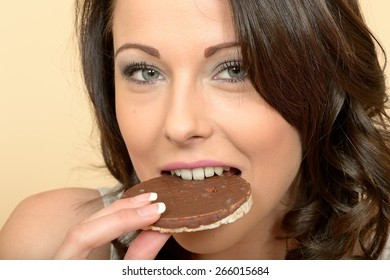 Attractive Beautiful Young Woman Eating A Single Milk Chocolate Covered Rice Cake Biscuit