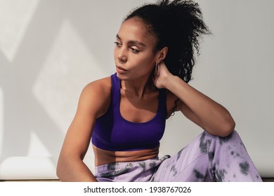 Attractive Black African American Woman Sitting In Stylish Hipster Fitness Outfit Violet Top And Pants On White Background, Summer Fashion Trend, Happy Smiling Curly Hair Sport Style