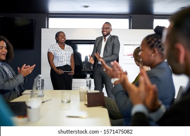 Attractive black businessman being encouraged by diverse multi-e