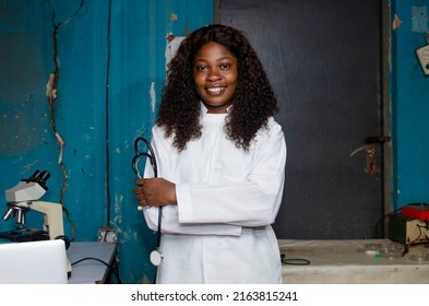 Attractive Black Female Lab Doctor Holding Stethoscope With Arms Crossed Whilst Looking At The Camera