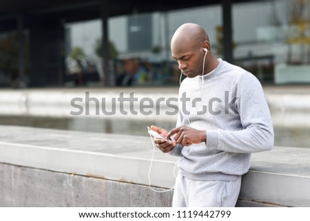 Attractive black man listening to music with earphones