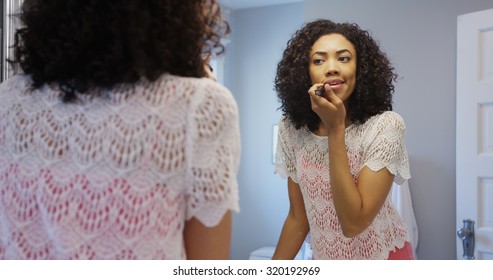 Attractive Black Woman Applying Make-up