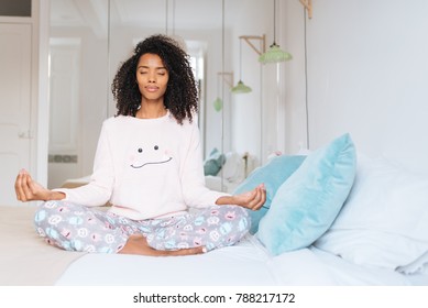 Attractive Black Woman Practicing Yoga And Relaxation Exercises On Bed