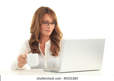 Attractive Blond Mature Business Woman Working On Her Laptop And Drinking Coffee ( Against White Background With Copy Space )