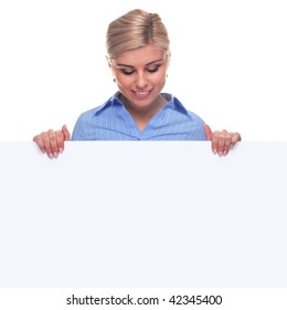 An Attractive Blond Woman Looking Down At The Blank Sign She Is Holding, The Board Is A Uniform Color So You Can Make It Larger If You Wish To Add Your Own Image Or Message.