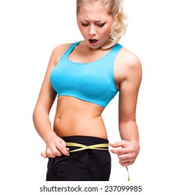 attractive blond woman looking shocked at her measure tape