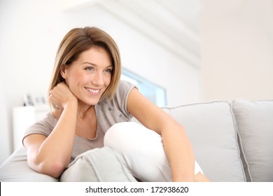 Attractive Blond Woman Relaxing In Sofa At Home