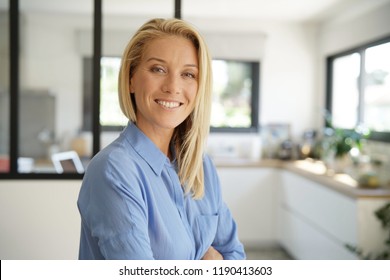Attractive blond woman standing with arms crossed