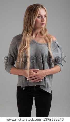 Attractive Blonde Caucasian Girl wearing Sweater, acting shy / demure